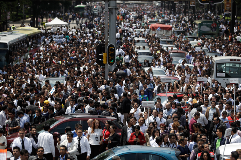 People evacuated from office buildings gather in Reforma Avenue after an earthquake in Mexico City. (Image: AP)